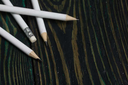 A set of white pencils for school. They lie on pine boards.の写真素材