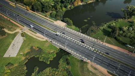 An overpass across the city river. Busy freeway. Aerial photography.の写真素材