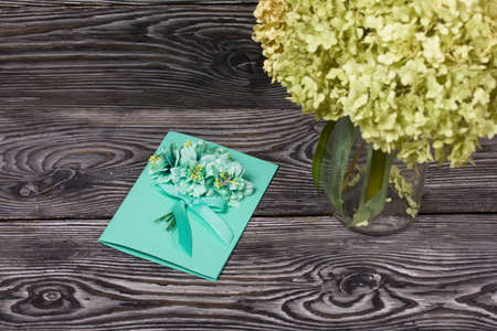 Homemade handmade postcard. Nearby there are materials for making postcards. On black pine boards.の写真素材