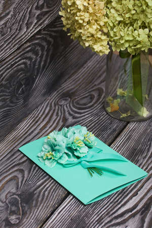 Homemade handmade postcard. Nearby there are materials for making postcards. On black pine boards.の写真素材