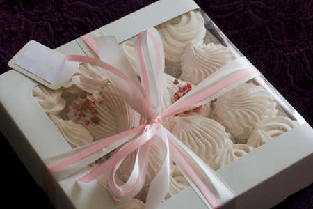 Homemade marshmallow in a gift box. Tied with a ribbon tied to a bow. On black pine boards.の写真素材