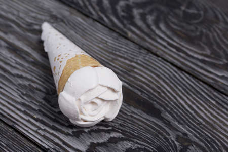 Homemade marshmallows are spread out on the table surface. Zephyr in a waffle cone. Made in the shape of a rose. Close-up shot.の写真素材