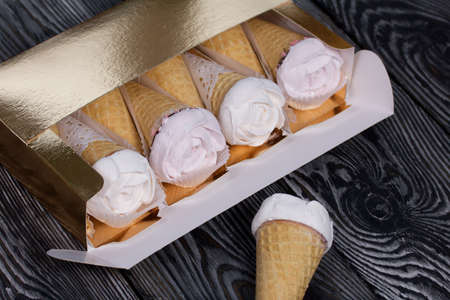 Homemade marshmallows in a craft box. Marshmallow in a waffle cone. Made in the shape of a rose. Close-up shot.の写真素材