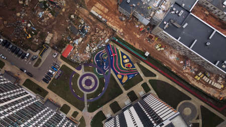 Construction of modern multi-storey buildings. Construction of a new city block. Buildings under construction and tower cranes. Aerial photography in cloudy weather.の写真素材