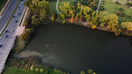 Flight over the autumn park. Trees with yellow autumn leaves are visible. The city highway is...