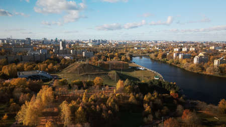 Flight over the autumn park. Park on the shore of a large lake. On the horizon there is a blue sky...