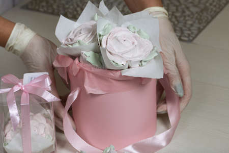 Zephyr roses in a hat box. Marshmallow in the form of roses and tulips. Close-up shot.