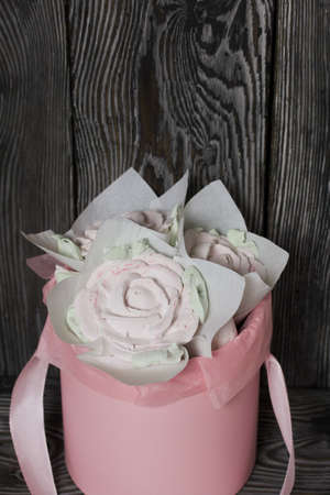 Zephyr roses in a hat box. Marshmallow in the form of roses and tulips. Close-up shot.