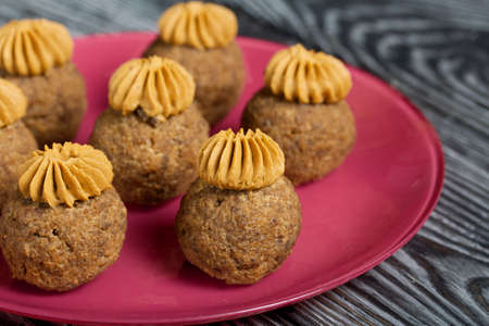 Banana cakes with butter cream. Lie on a plate. On black pine boards. Close-up shot.