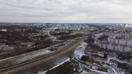 Construction site in a city vacant lot. Close to populated urban areas. Traces of heavy construction equipment are visible on the ground. snow covered earth. aerial photography.の写真素材
