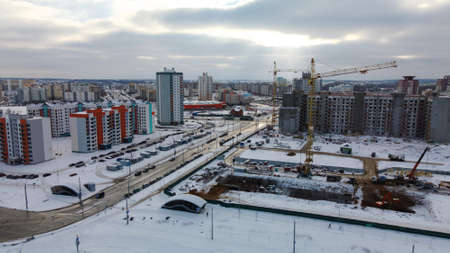 Construction site of a modern city block. High rise buildings under construction. construction tower cranes. Construction site in winter. Aerial photography at sunset.のeditorial素材