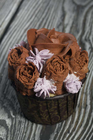 Cupcakes with cream and mascarpone. On pine boards. close-up.の写真素材