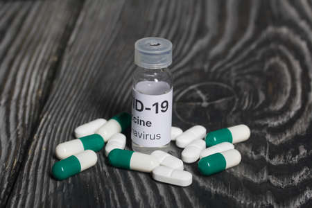 Vial with vaccine and pills. medicines for coronavirus. Shot close-up.