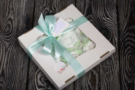 Roses, tulips and chrysanthemums from marshmallows. Zephyr flowers. In craft packaging. Tied with ribbon.の写真素材