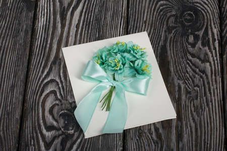 Homemade greeting card in green tones. On pine boards.
