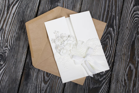 Homemade greeting card in white. With decorative elements. Ribbons, flowers and leaves are attached...