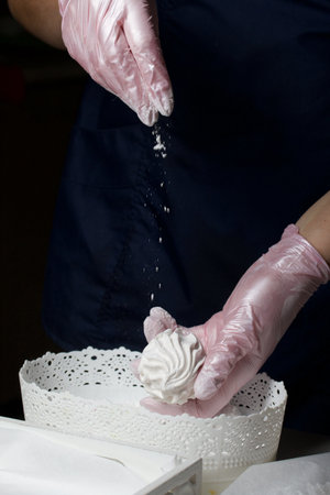 homemade zephyr. White tray with marshmallows. A woman sprinkles marshmallows with dextrose.の写真素材