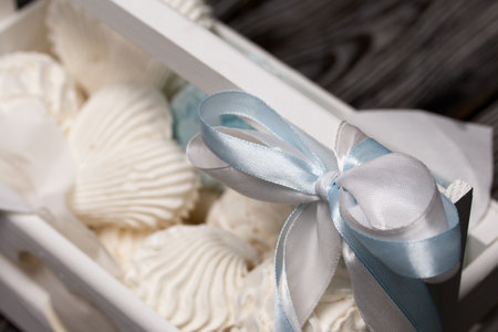 Marshmallow cones. homemade zephyr. Packed in a wooden decorative box. On the background of the boards. close-up.の写真素材