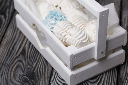 Marshmallow cones. homemade zephyr. Packed in a wooden decorative box. On the background of the boards. close-up.の写真素材
