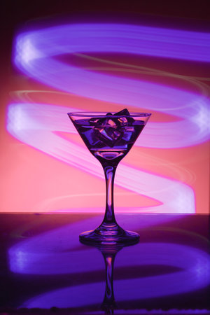 Martini glass with ice. On the bar. Against the background of neon light.の写真素材
