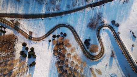 A winding bike path in a city park. City park in winter. Snow lies on the ground. aerial photography.の写真素材