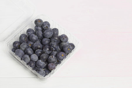 Large blueberries in a decorative container. International day without diets. On a white background. close-up.の写真素材