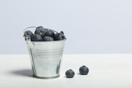 Large blueberries in a decorative bucket. International day without diets. On a white background. close-up.の写真素材