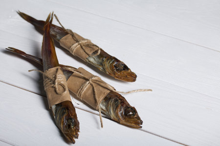 Putassu Cold smoked. The fish is wrapped with a strip of paper. Tied with linen twine. close-up.の写真素材