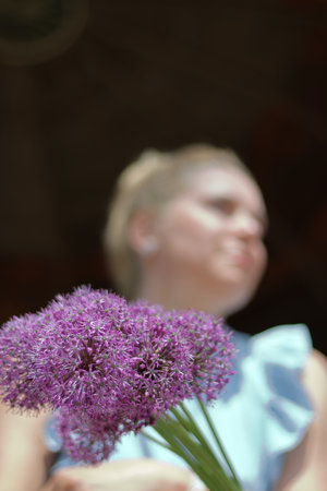 A waist portrait of a woman with a bouquet of wildflowers. Looks into the camera.の写真素材