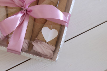 Zephyr in waffle cones. Packed in a box. Tied with ribbon. On board painted white.の写真素材
