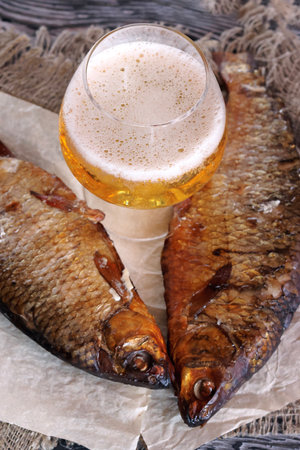 Smoked roach and a glass of beer. on paper. close-up.の写真素材