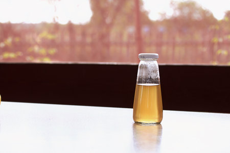 Yellow compote in a glass bottle. Summer drink from berries and fruits.の写真素材