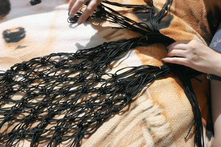 A woman weaves a string bag from a polymer cord. Homemade shopping grid.の写真素材