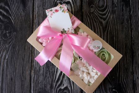 Homemade marshmallows in a paper gift box. Zephyr flowers. The box is tied with a ribbon tied into a bow. Label for the text.の写真素材