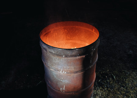 fire burning inside a metal barrelの写真素材