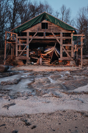 old wooden row boat in a abandoned shackの写真素材