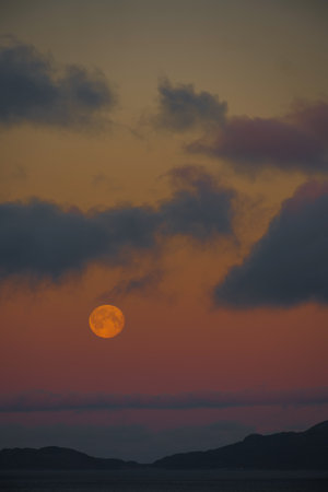 full moon over snow covered mountain landscape during duskの写真素材