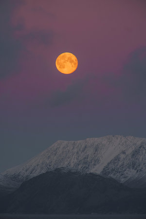 full moon over snow covered mountain landscape during duskの写真素材