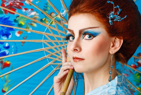 Attractive geisha in a smart dress with an umbrella, photographed in the studioの写真素材