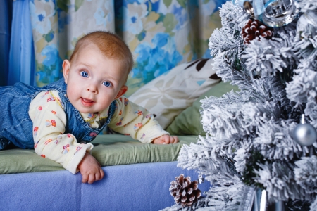 Redhead babe with blue eyes lies near Christmas treeの写真素材
