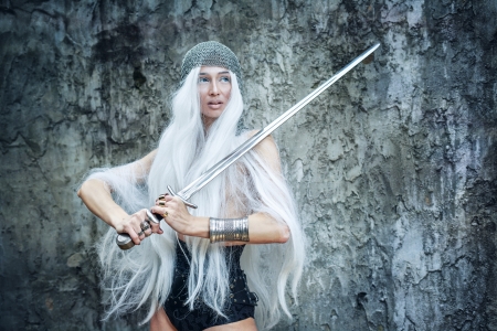 Attractive gray-haired maiden warrior in armor with sword in handの写真素材