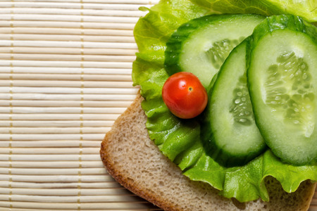 Appetizing bread with lettuce, tomatoes and cucumber shot closeupの写真素材