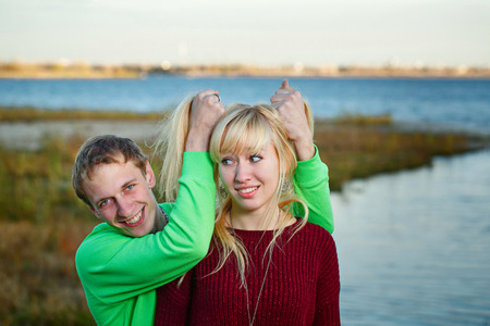 Young couple fooling around on the beach day in autumnの写真素材