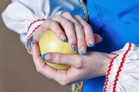 Girl holds in her hands with manicure ripe apple shot close upの写真素材