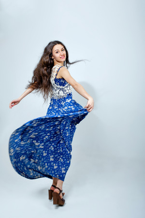 Attractive young girl in beautiful blue dress shot in studioの写真素材