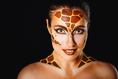 Close portrait of a young attractive girl with a make-up of an animal shot in a studioの写真素材