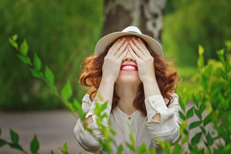 Portrait of a young attractive girl in a hat sunny summer day in the parkの写真素材