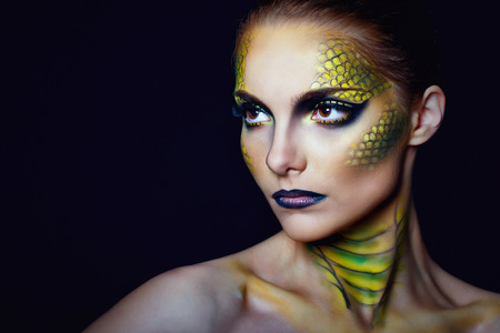 Attractive young woman in makeup snake shot in the studioの写真素材