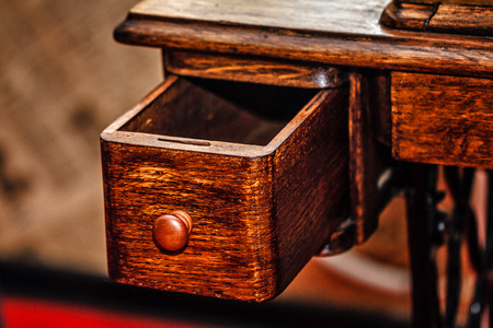 Retractable drawer is pulled out. Vintage oak table closeup shot