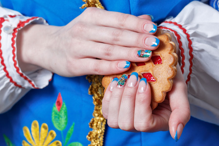 Female hands with beautiful manicure hold tasty cookiesの写真素材